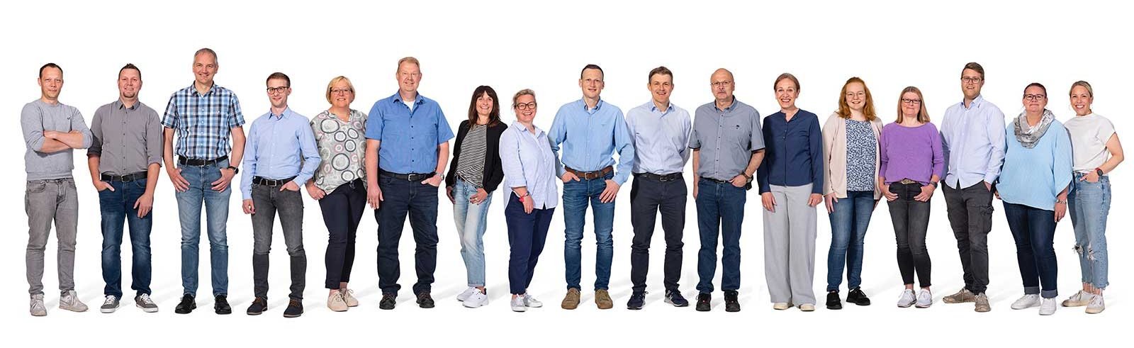 Die Gruppe besteht aus Männern und Frauen unterschiedlichen Alters, die in einer freundlichen Pose zusammenstehen.